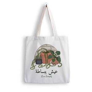 the mockup tote bag with arabic phrase translating to live simply